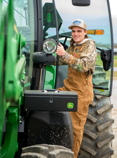 Student riding on tractor