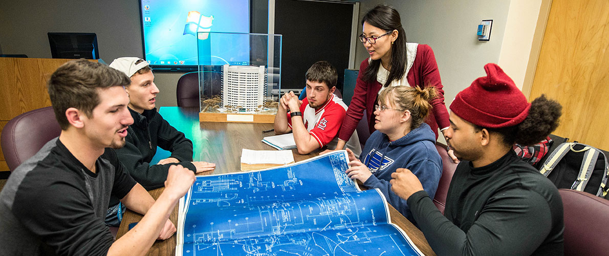 Group of SIU QEM Students look over blueprints