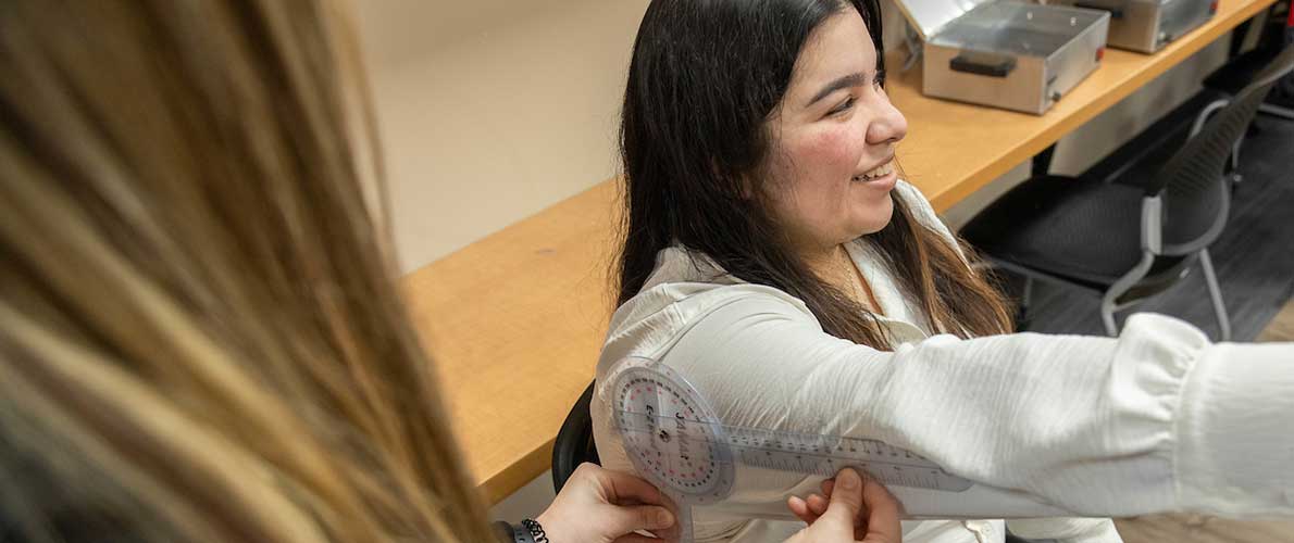 SIU occupational therapy student working with patient on arm rotation