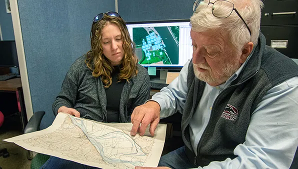 SIU Anthropology Student studying Kaskaskia Town Maps Plot & Building Locations