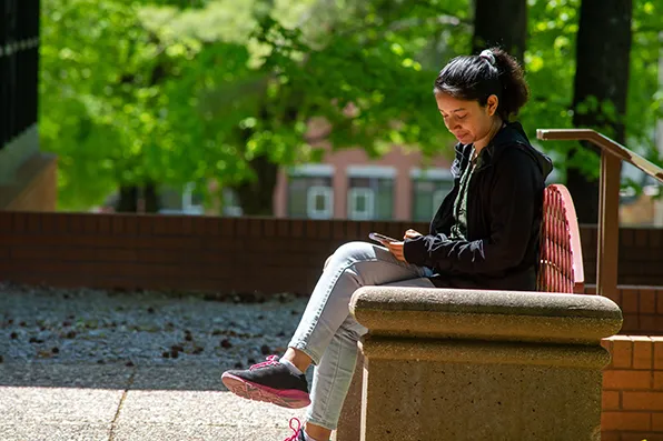 SIU Student sitting on a bench on Campus