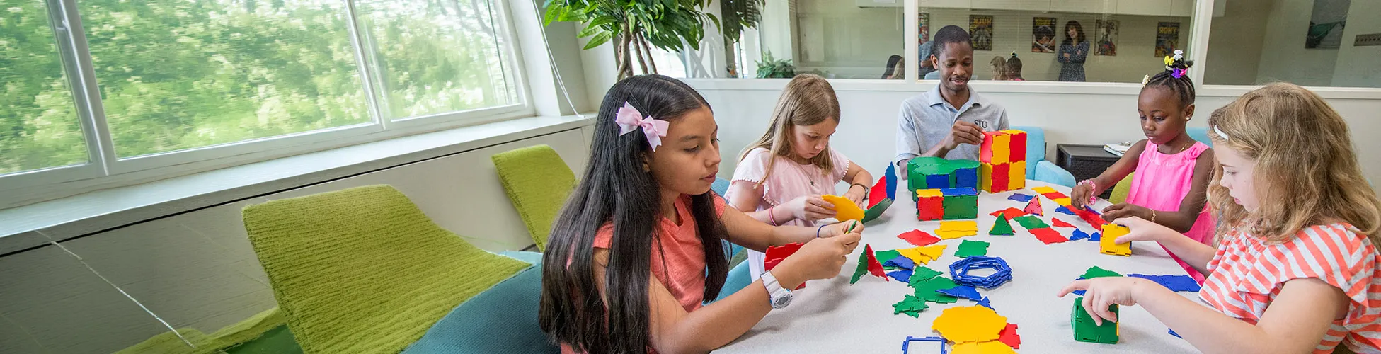 Early Childhood Students work with kids building blocks