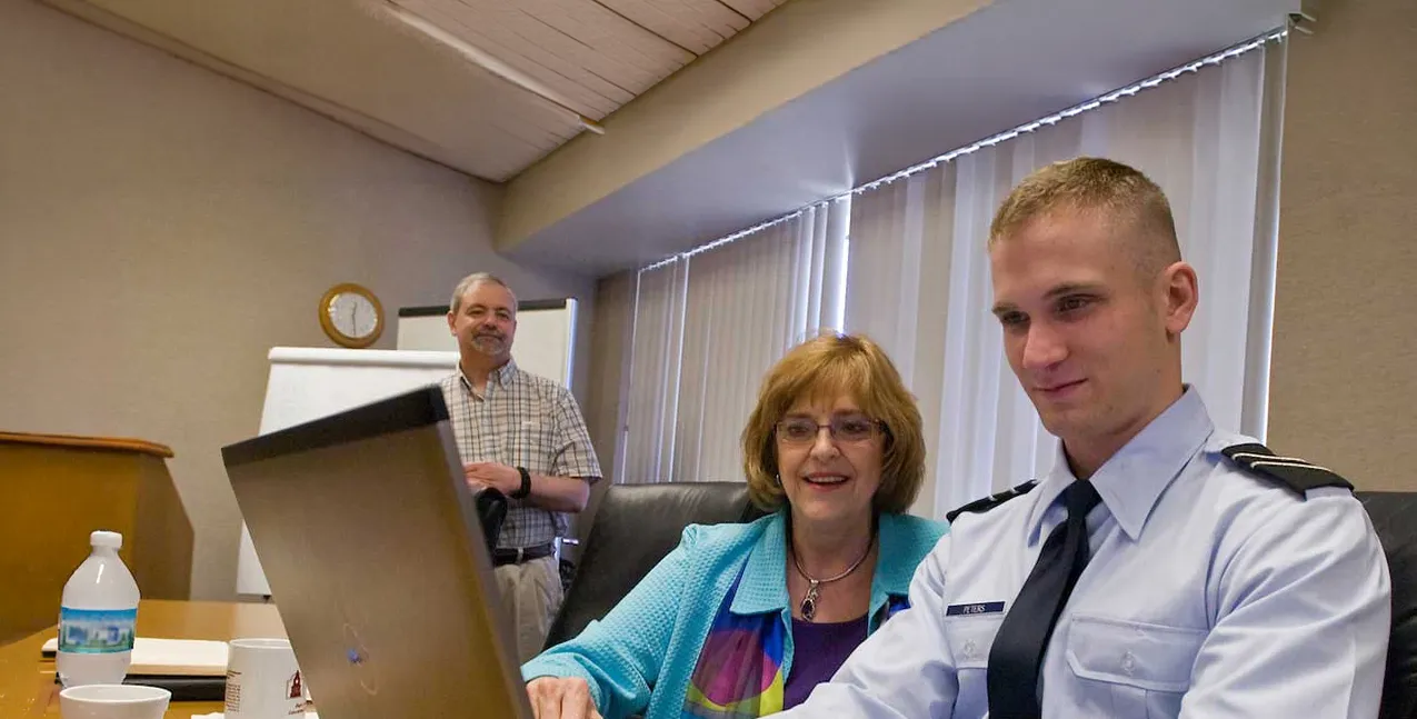  Organizational Learning, innovation, and development professor works with student on a computer